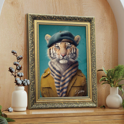 Framed artwork of a tiger wearing a coat and beret in a gold frame on a wooden surface