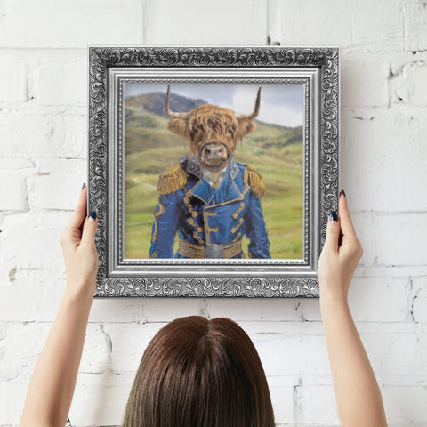 Framed artwork of a highland cow in a blue coat by S.Golding ready to hang on wall